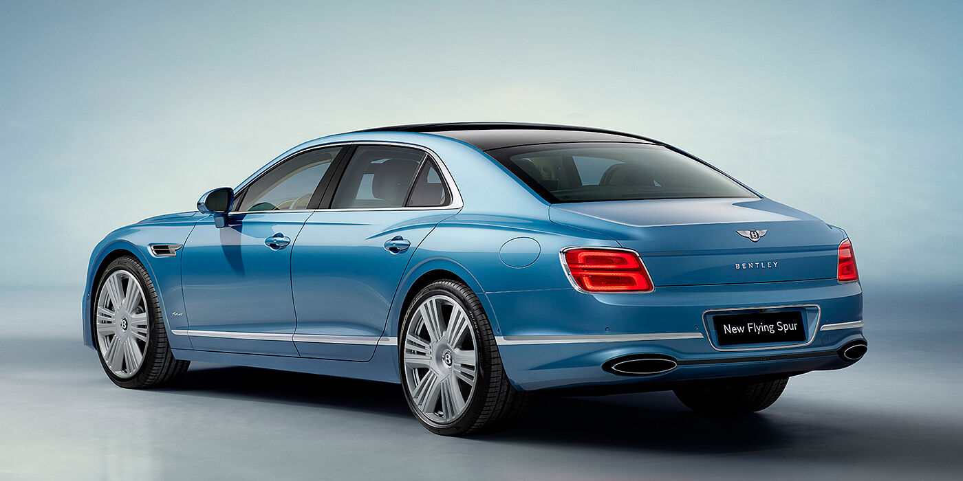 Bentley Tunbridge Wells New Bentley Flying Spur Azure sedan rear view in Light windsor blue by Mulliner paint with 22 inch Azure wheels and chrome exterior details